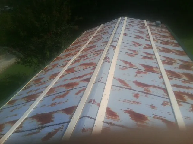 Rusted metal roof panels with new wood purlins before replacement — Storm Damage Roof Repair in Algona by Roofing Brothers