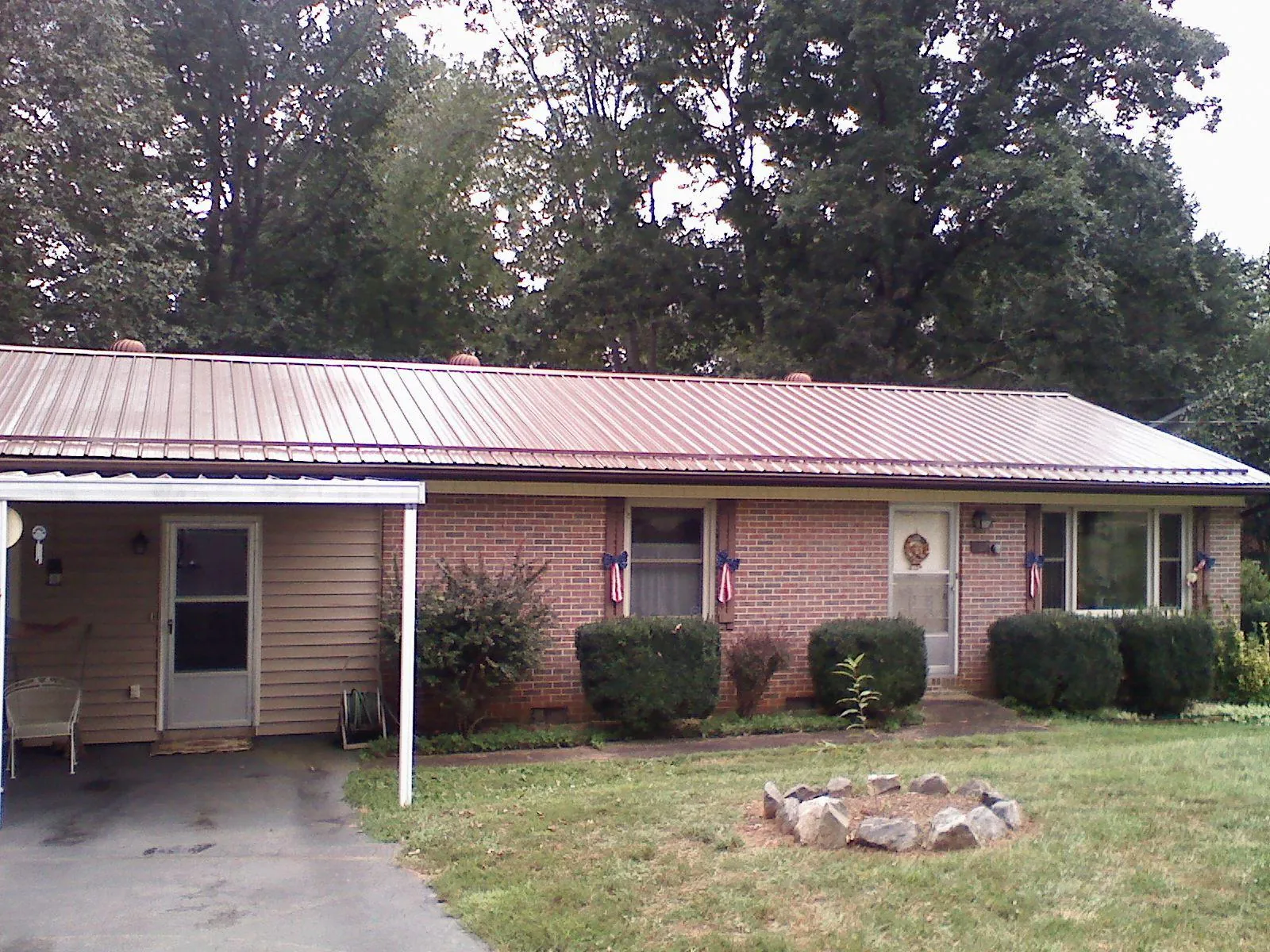 Bronze metal roof and carport on a brick ranch home — Roof Repair work by our crew in Algona